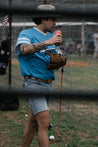 A man wearing Moontowers shorts and a Zilker Belts baseball mitt.